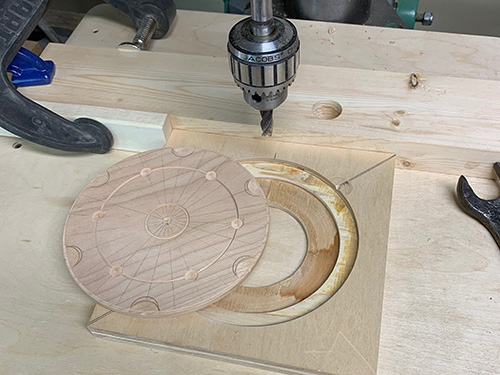 Jig for drilling holes in turned manhole cover