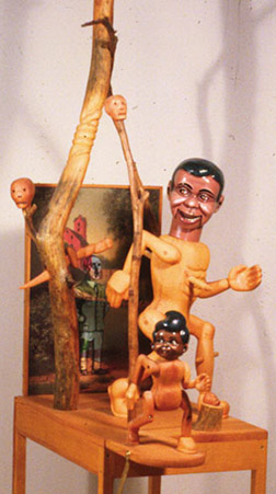 Charley and Roberto Meet the 3rd Reich, 1997 Pine, enamel, cardboard, mixed, media 82" x 32" x 19" This piece comes from Michael's fascination with infamous people like Hitler who have such negative imagery. But the title also refers to old movies like "Abbot and Costello Meet Frankenstein.".