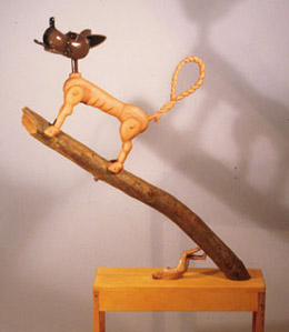 The Big Sleep, 1999 Pine, enamel 65" x 31" x 12" Like the Bogart film, Mike describes this piece about death, but in this case represented by the dog out on the limb. The tiny figure that seems to be holding the whole thing up is a carving from the 30s or 40s that Mike picked up years ago.