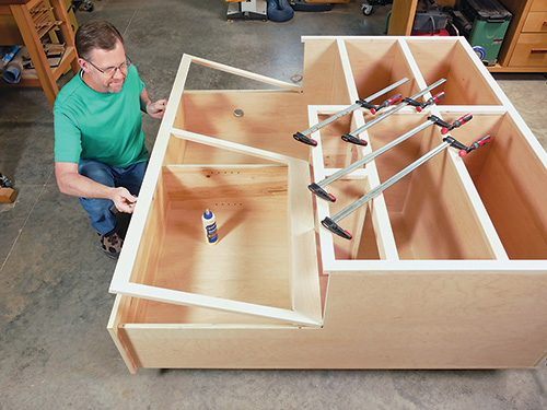 Gluing and clamping face frame to miter station cabinet