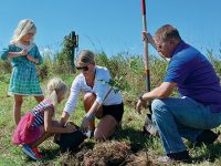 A family planting trees