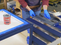 Applying a layer of milk paint to wooden slats
