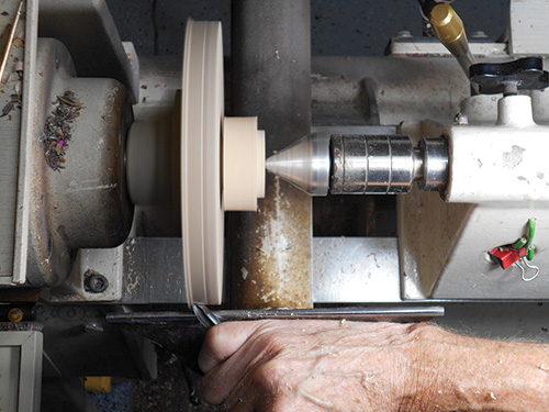 Tailstock support on a lathe turning a paper towel holder