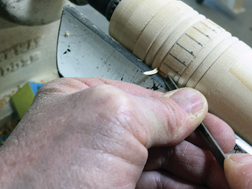 Using gouge to cut out ferrule marking on pencil box