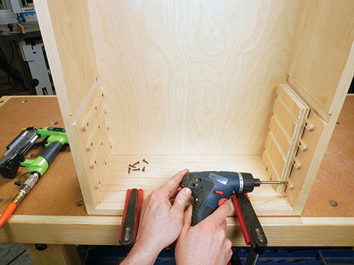 Installing drawer guides inside tool storage cabinet frame