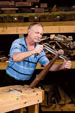 Using draw knife to finish shaping of cabriole leg for queen anne highboy