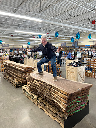 Rob Johnstone stands on a pallet of slab wood