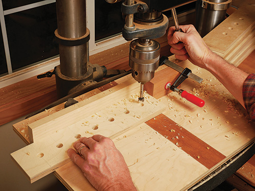 Boring holes in shelf for router bit storage in router bit cabinet