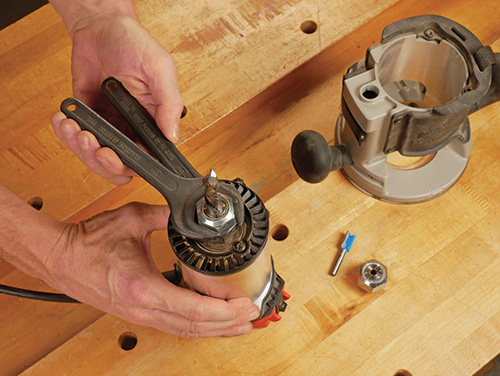 Unscrewing collet nut to remove router bit