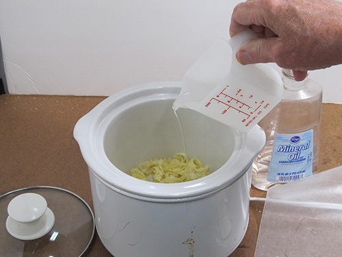 Melting down beeswax shavings and mineral oil in a crockpot