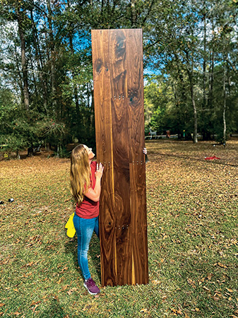 Sarah Listi holding large piece of lumber