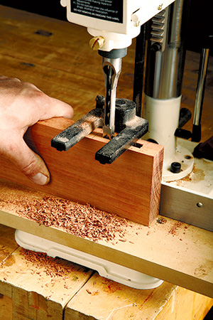 Mortising machine cutting lyptus lumber for screen door