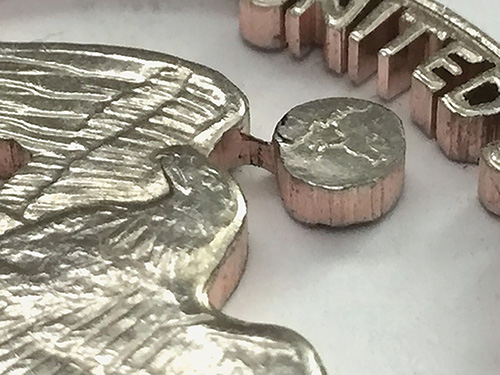 Close-up details of a scroll sawn coin cutout