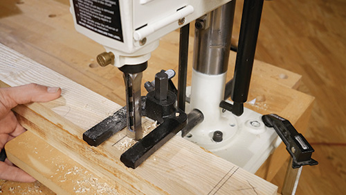 Using a mortising machine to chop out table cross bracket