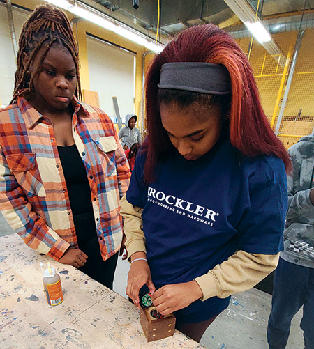 Student installing speaker into case