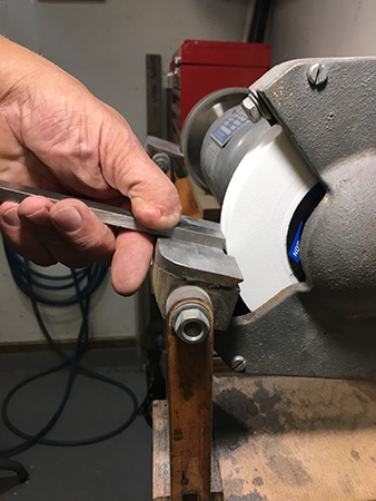 Sharpening a scraper with the edge downwards