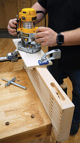 Clamping shop-made jig to shelf for cutting shelf hardware slots