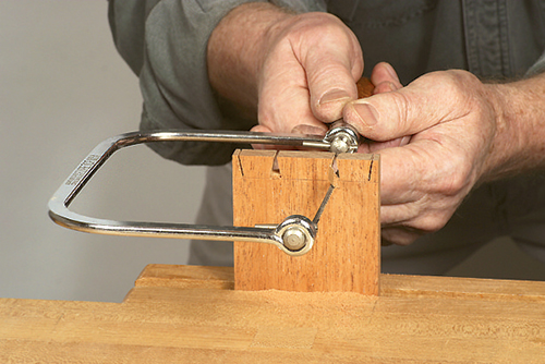 Cleaning dovetail pins with a coping saw