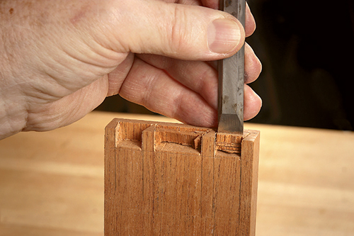 Cleaning waste from dovetail with a chisel