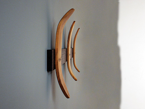 Side view of steam bent coat hooks installed on a wall