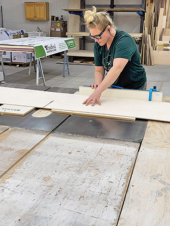 Stevie Estler cutting panels with a table saw