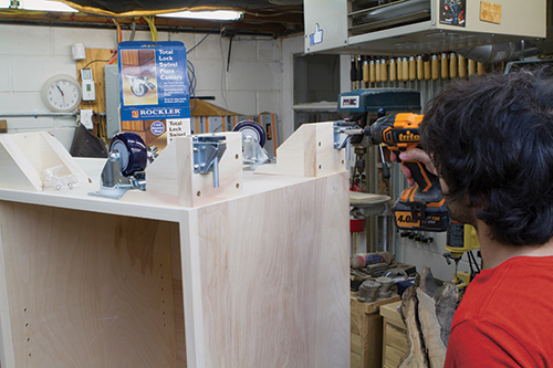 Attaching casters to base of outfeed table