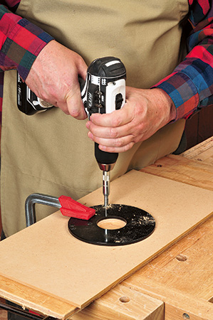 Using router plate to guide hole drilling in router table base