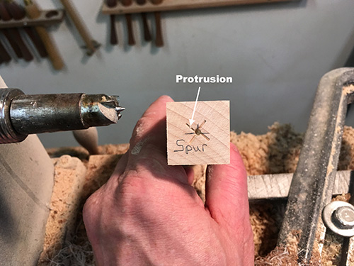 Marked spur location in spindle turning for remounting