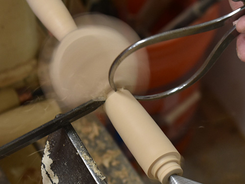 Measuring width of tea strainer handle next to cup