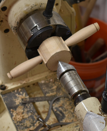 Lathe tailstock holding tea strainer cup in place