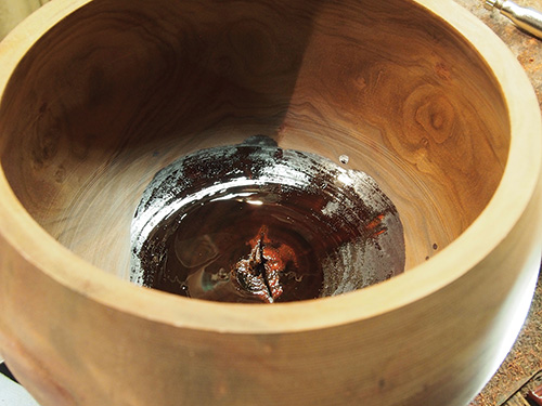 Soaking bowl bottom with lacquer to stabilize wood 