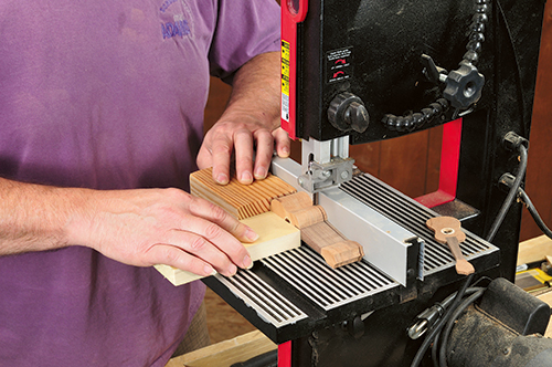 Individual 1/8"-thick ornaments are sliced off the log using a 3/8"- or 1/2"-wide blade in the band saw. The band saw's fence guides the cut while a pair of push blocks keep fingers safe.