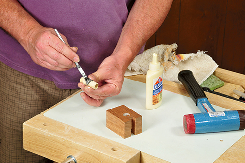 Use a small brush to apply glue to the outside of the hollowed sound hole ring dowel and the hole bored into the uke body before pressing the dowel into place. If the fit is tight, gently pound it in.