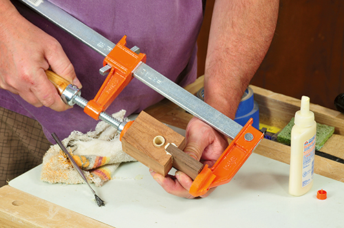 A small bar clamp presses the uke ornament’s neck into the body until it’s fully seated.