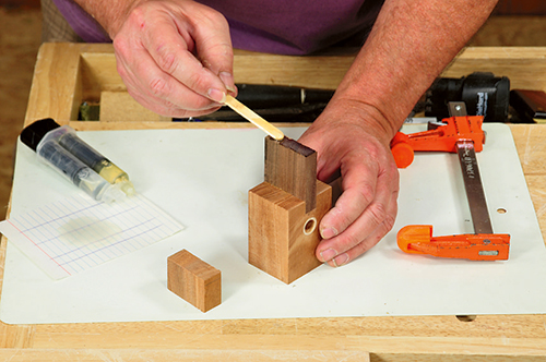 A well-mixed application of two-part epoxy glue is used to adhere the uke's headstock to the end of the neck.