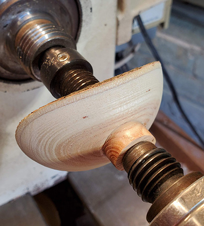 Partially turned umbrella ornament in lathe