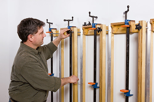 Adjusting carriage bolts in press bars on wall mounted panel press