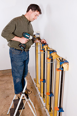 Mounting pipe clamps onto wall mounted panel press