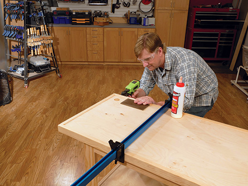 Gluing and nailing trim pieces around workbench top
