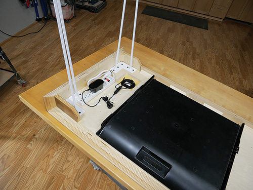 Underside of waterfall desk with power cable and desk tray