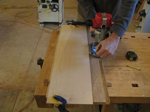 Figure 2: A thin piece of plywood acts as a straightedge, guiding the router through the rabbet cut. The thin piece of remaining waste was removed with the next cut.