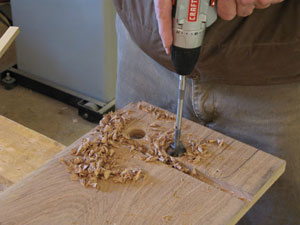 Figure 3: Use a large diameter drill bit to shape the ends of the tool cutouts. Be careful to hold the bit back from the edge of the dado by just a hair.