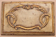 Antique white, made from raw umber glaze over white paint, on a carved cherry panel. 