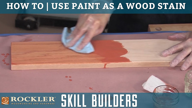 Wiping paint across a piece of lumber