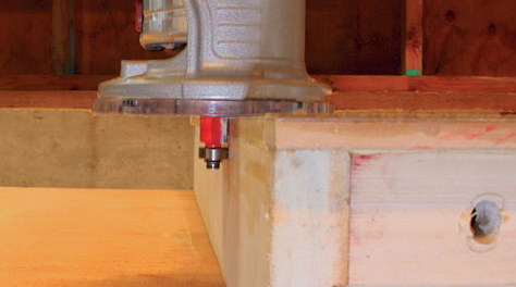 Trim the laminate and MDF layers even with the outside edges of the router table frame using a piloted flush-trim bit.