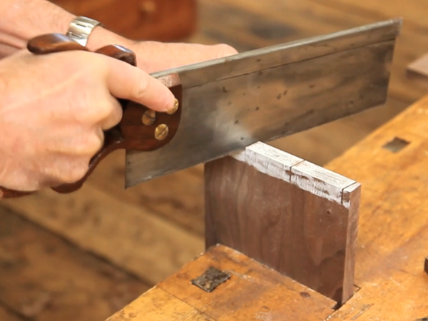 Hand sawing a dovetail pin
