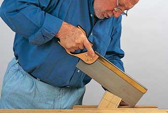 The author places the laid-out tenon on the mortise to determine how close to saw to the line. For Cut 1 he starts at the far edge and makes a kerf parallel to the end.